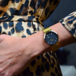 Elegante schwarze Damenuhr aus der Andrea Cervo Kollektion mit goldenem Milanaise-Armband und feinen minimalistischen Details - Am Handgelenk